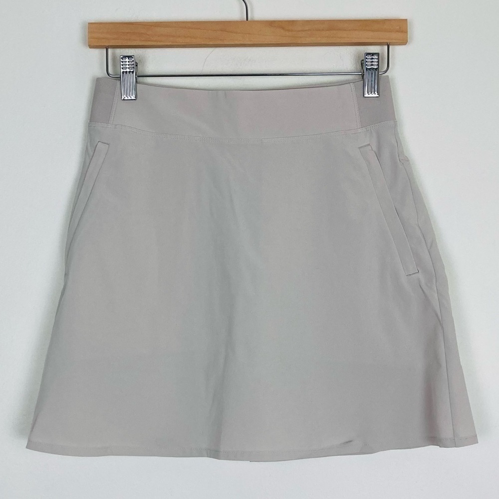 Athleta pale tan / ecru athletic skirt with side and back pockets. Size 0